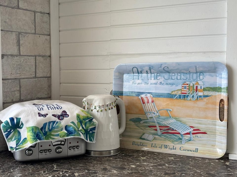 A cheerful kettle and tray bring a pop of beachy colour to the kitchen.