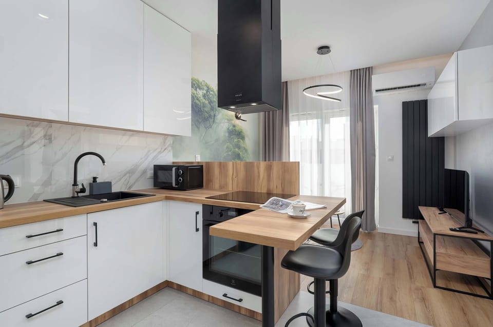 The fully equipped kitchenette with a stone countertop and view of the dining area allows convenient meal preparation any time of day.

