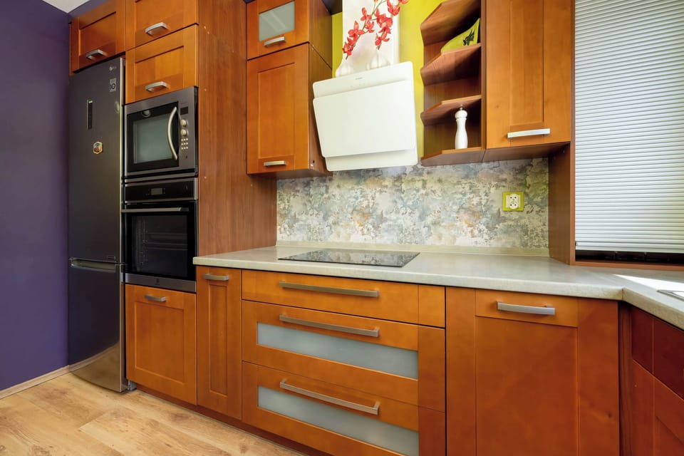 Modern kitchen units in warm wood tones and stylish lighting combine functionality with aesthetics.

