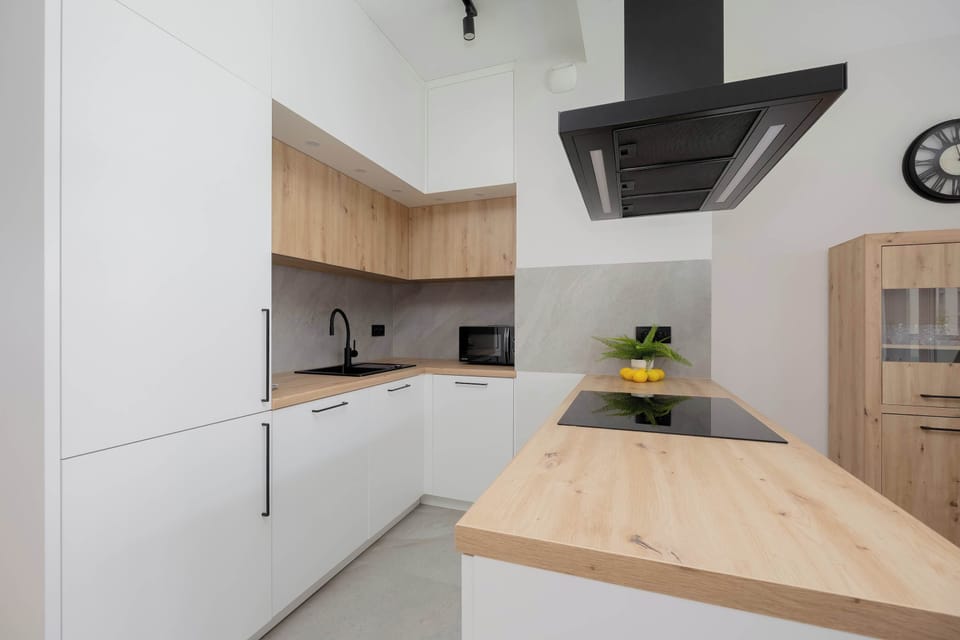The fully equipped kitchen with bright cabinetry and wooden countertop provides perfect conditions for cooking your own meals.