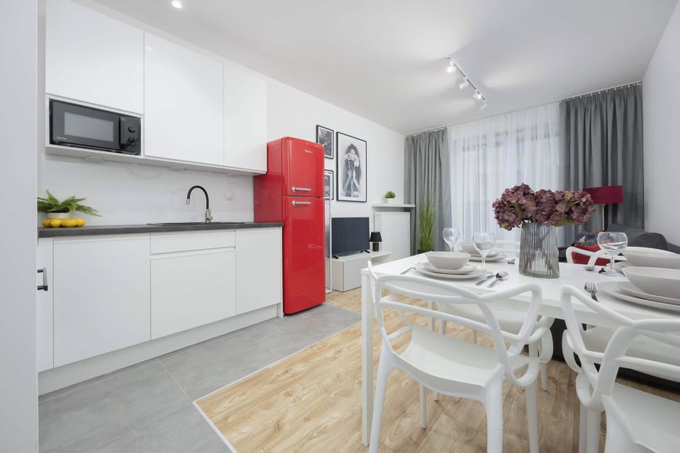 The modern kitchen with red accents and sleek finishes gives you freedom to cook and serve meals effortlessly.