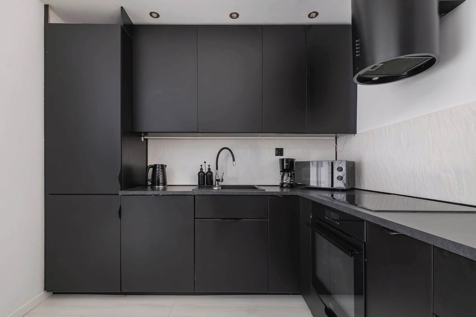 A dark, elegant kitchen with full equipment makes cooking comfortable and enjoyable.







