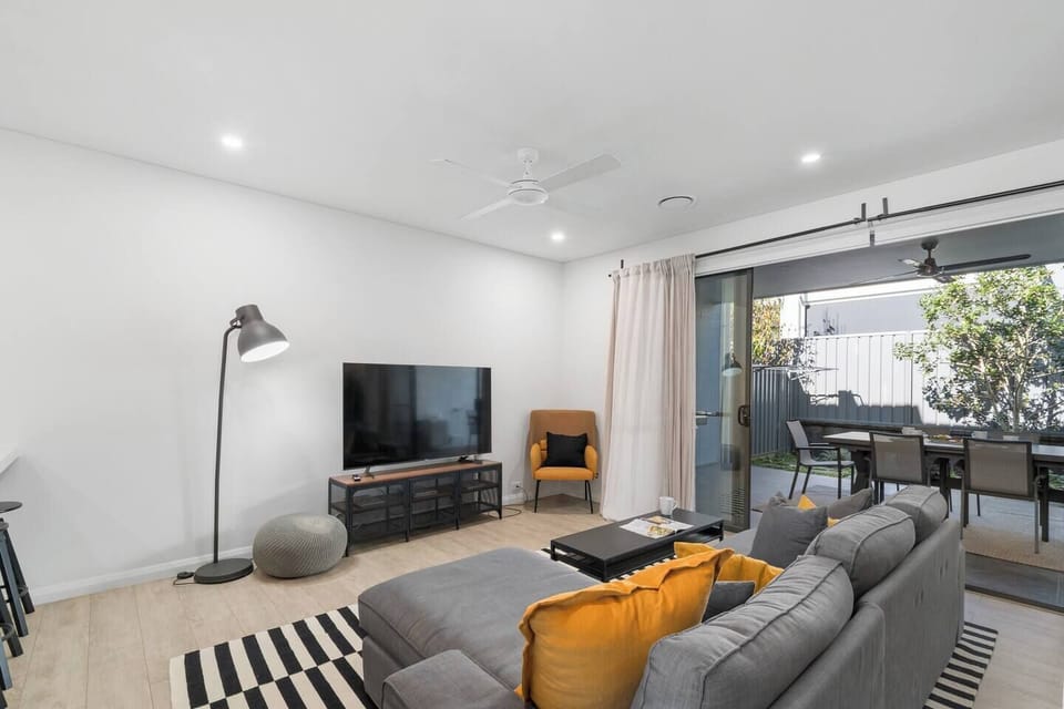 Unwind in the main living area, featuring plush seating, a large TV, ambient lighting, and direct access to the covered patio for seamless indoor-outdoor living.