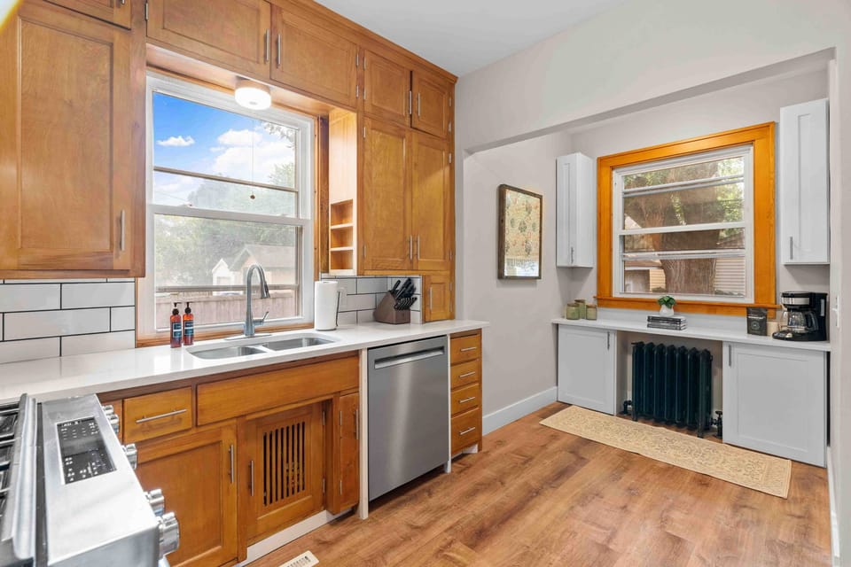 Your fully equipped kitchen awaits with warm wood cabinetry, modern appliances, and bright windows for cooking memorable meals.