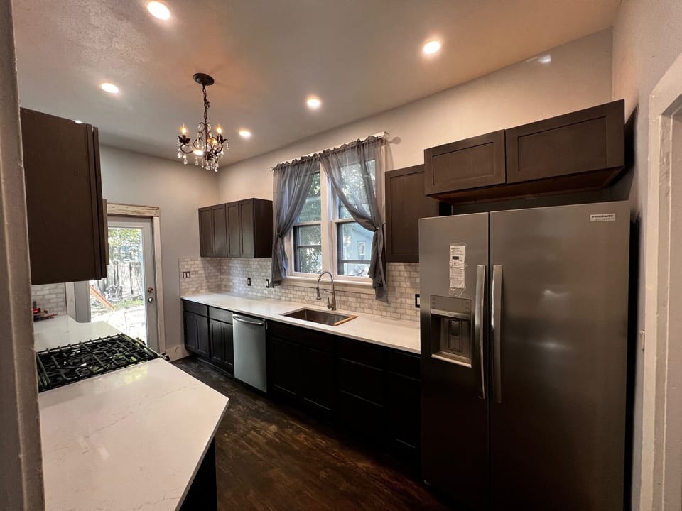 other side of galley kitchen with full glass door out to backyard/patios