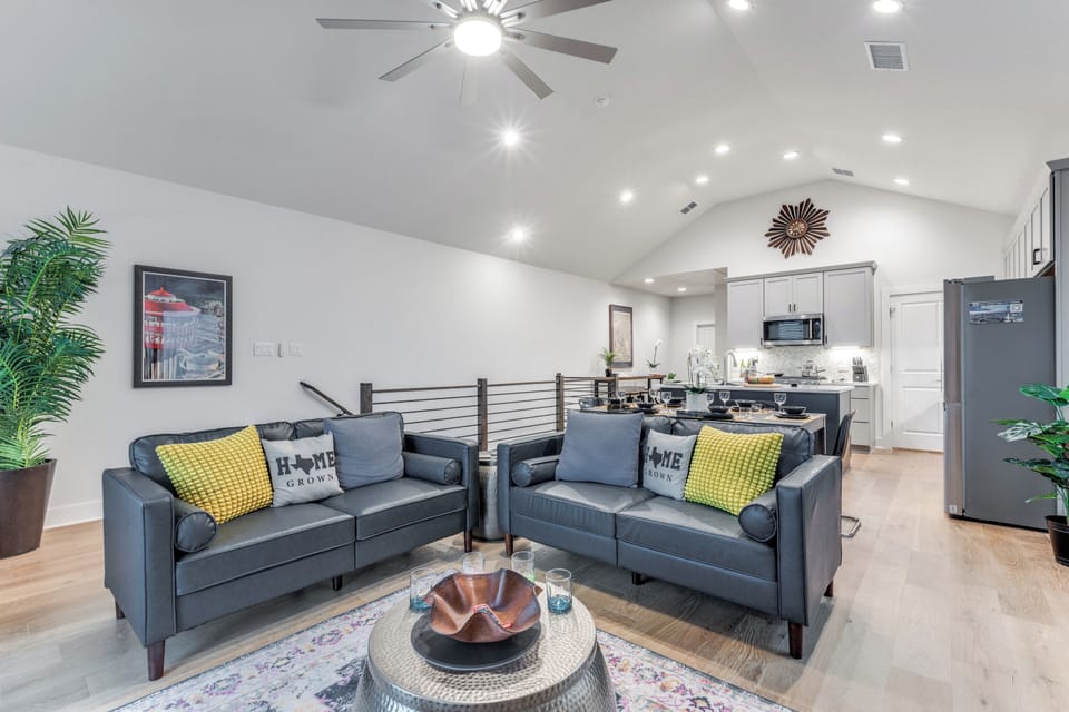Living room has 2 couches, 75" Roku Smart TV and a view of Tower and Alamodome