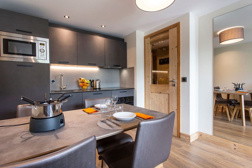 The sleek kitchen showcases contemporary appliances and ample counter space, making it an ideal setting for family meals and gatherings after a day on the slopes.