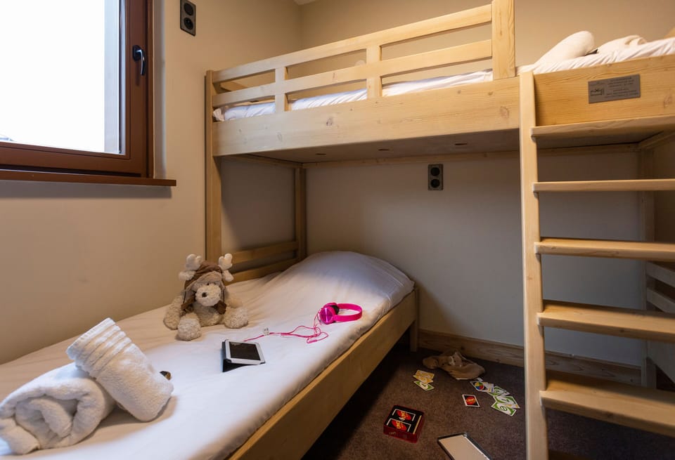 Cosy bunk space with soft bedding and warm lighting, offering a restful retreat for kids or teens.