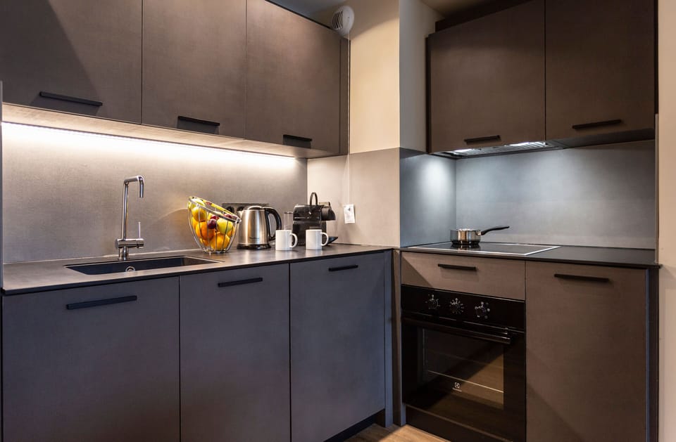 Sleek matte cabinetry and underlit counters elevate this gourmet kitchen’s modern mountain charm.
