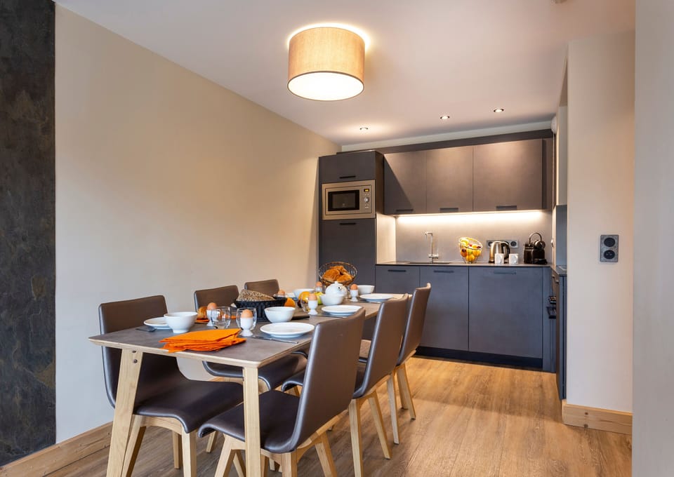 Chic dining corner with contemporary lighting and natural tones, perfect for après-ski dinners.
