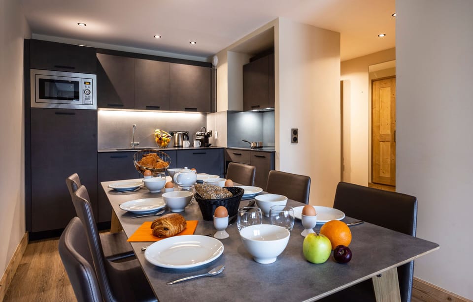 Modern open-plan kitchen and dining area featuring sleek finishes and stylish pendant lighting for cozy gatherings.