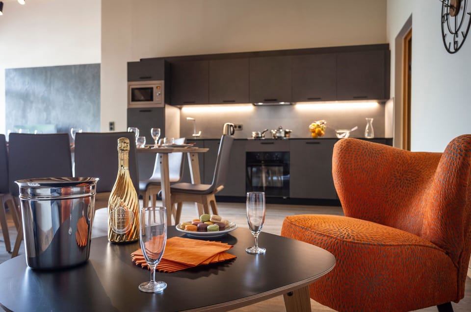 Sleek kitchen and dining area featuring a pop of orange and sparkling wine on ice.