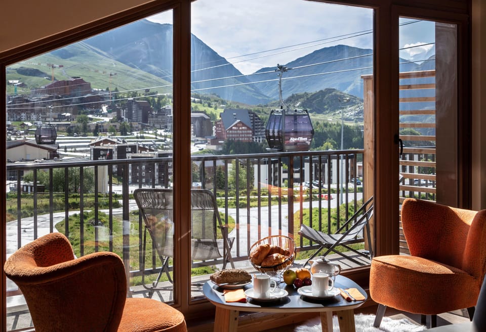 Cozy breakfast setup on the balcony with unbeatable views of the Alpine village and peaks.