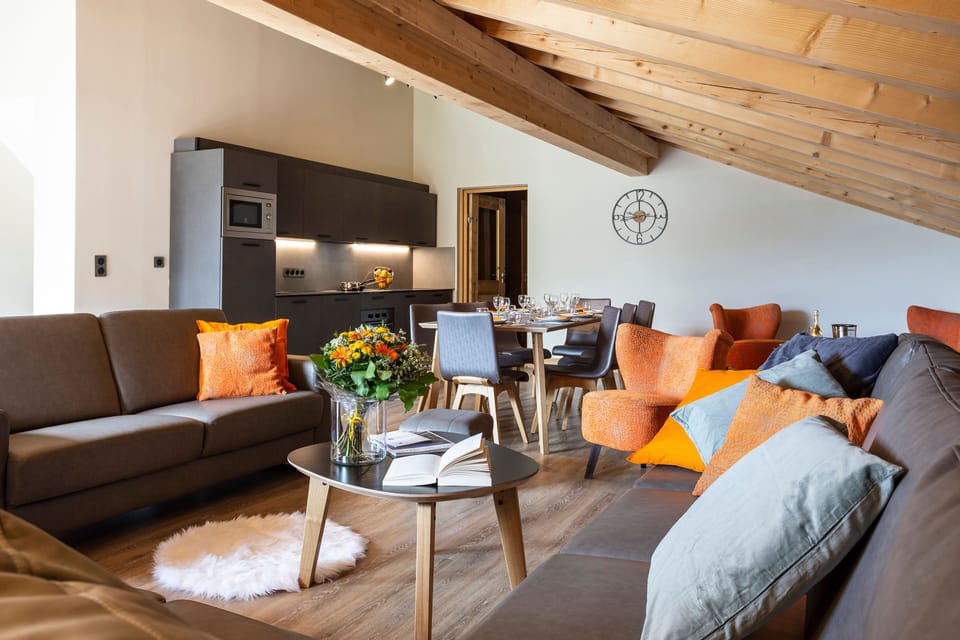 Spacious open-plan living room with bold accents and warm wood finishes, ideal for relaxing together.