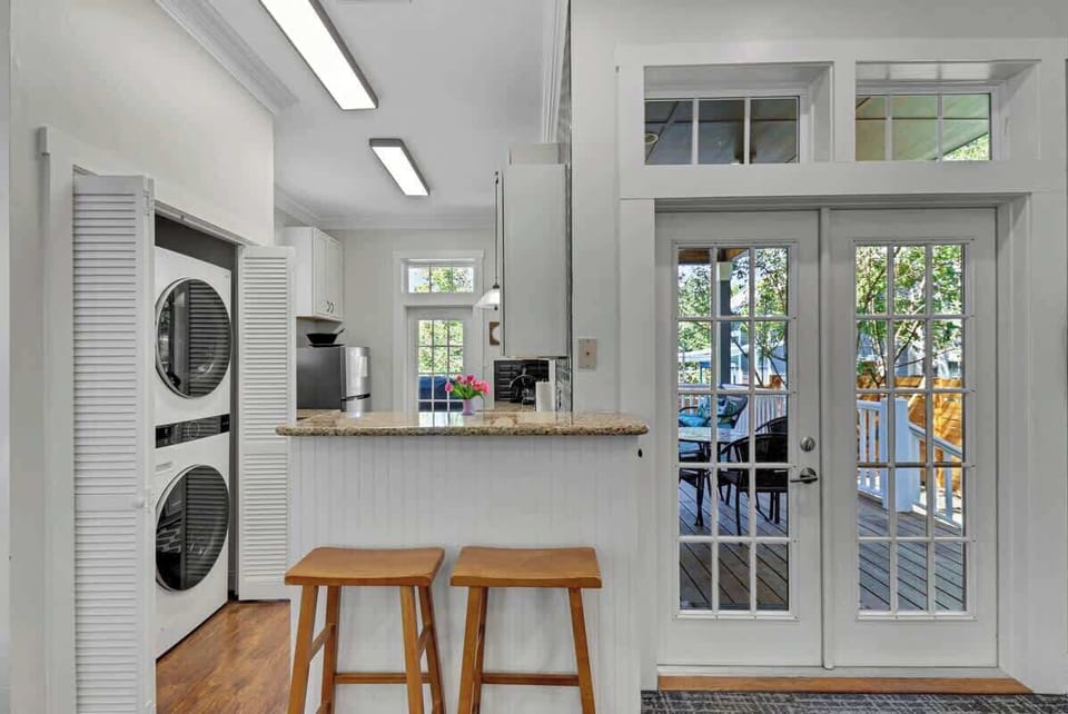 Kitchen Main House with Full-Size Laundry: Modern elegance with a breakfast bar and views to the sunlit porch!