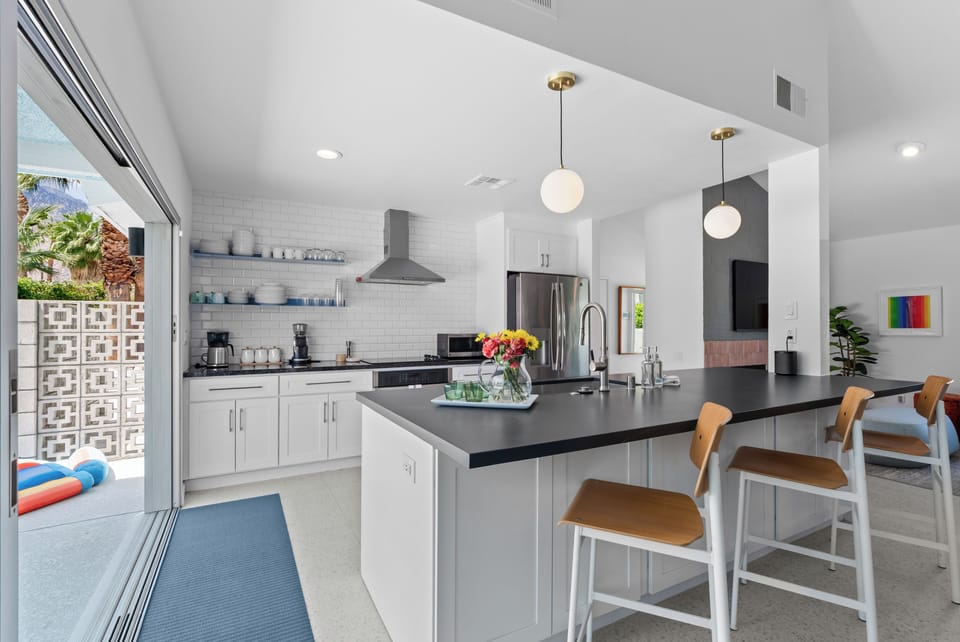 Modern kitchen with large island & backyard pool views