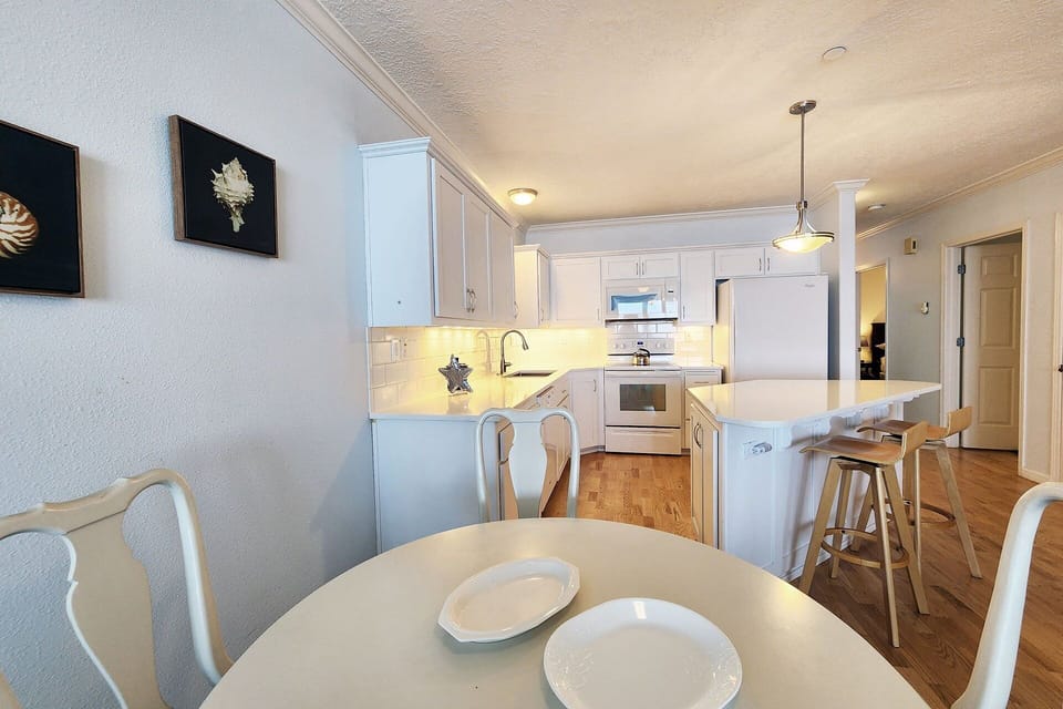 Cooks in the kitchen while others keep them company.