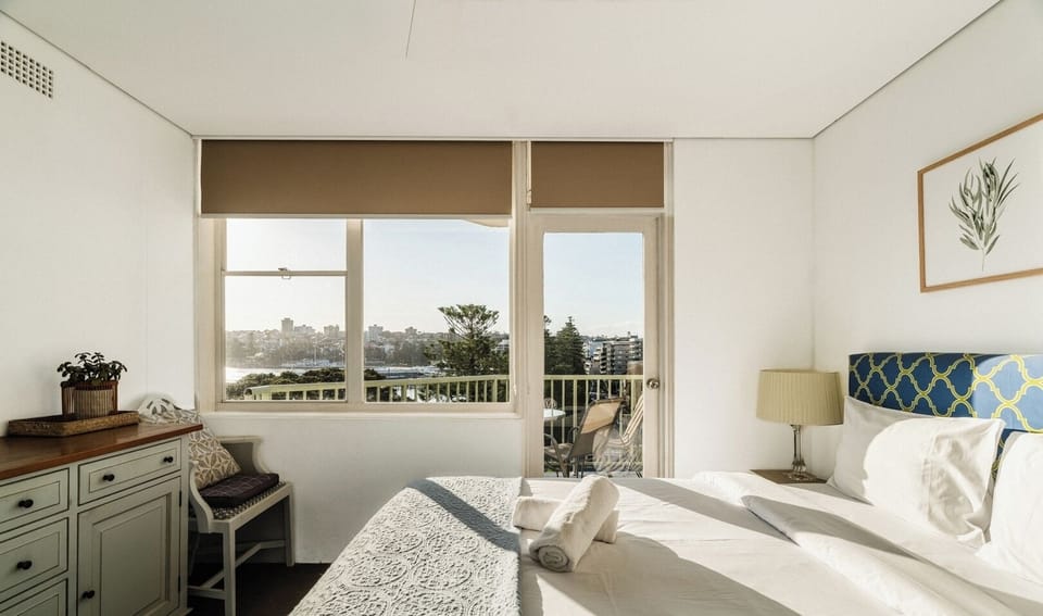 A bright, airy bedroom featuring a rustic wooden dresser