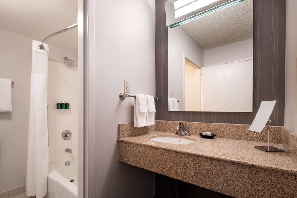 Unwind on plush bedding beside a cozy lounge seating area.
