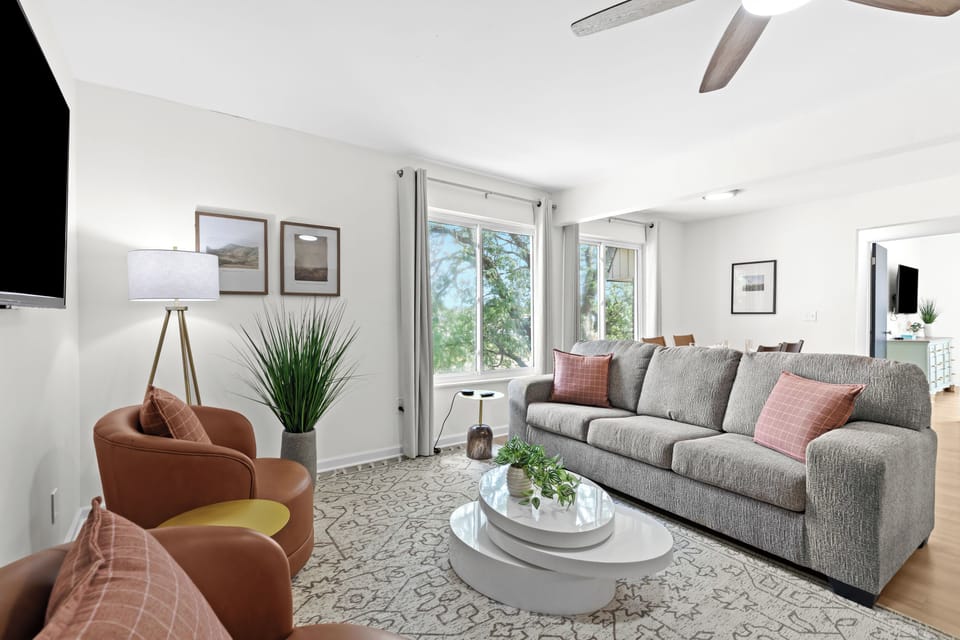 Spacious seating area with plush sofa, modern armchairs, and large windows for natural light.