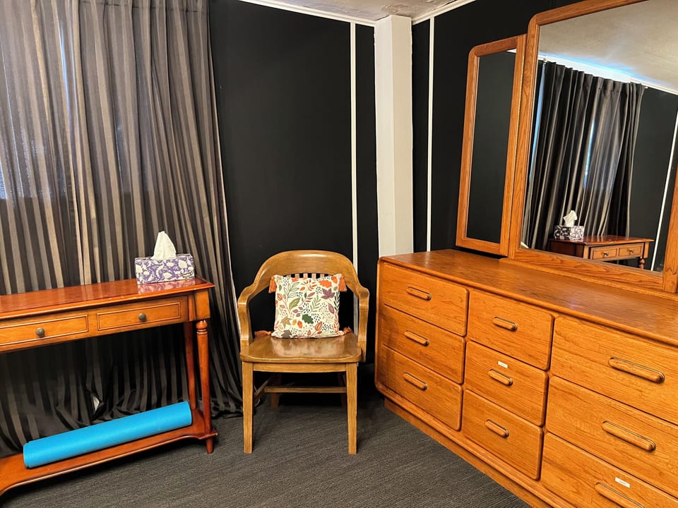 bedroom with yoga mat, dresser, mirrors, dehumidifier, and closet with hangers