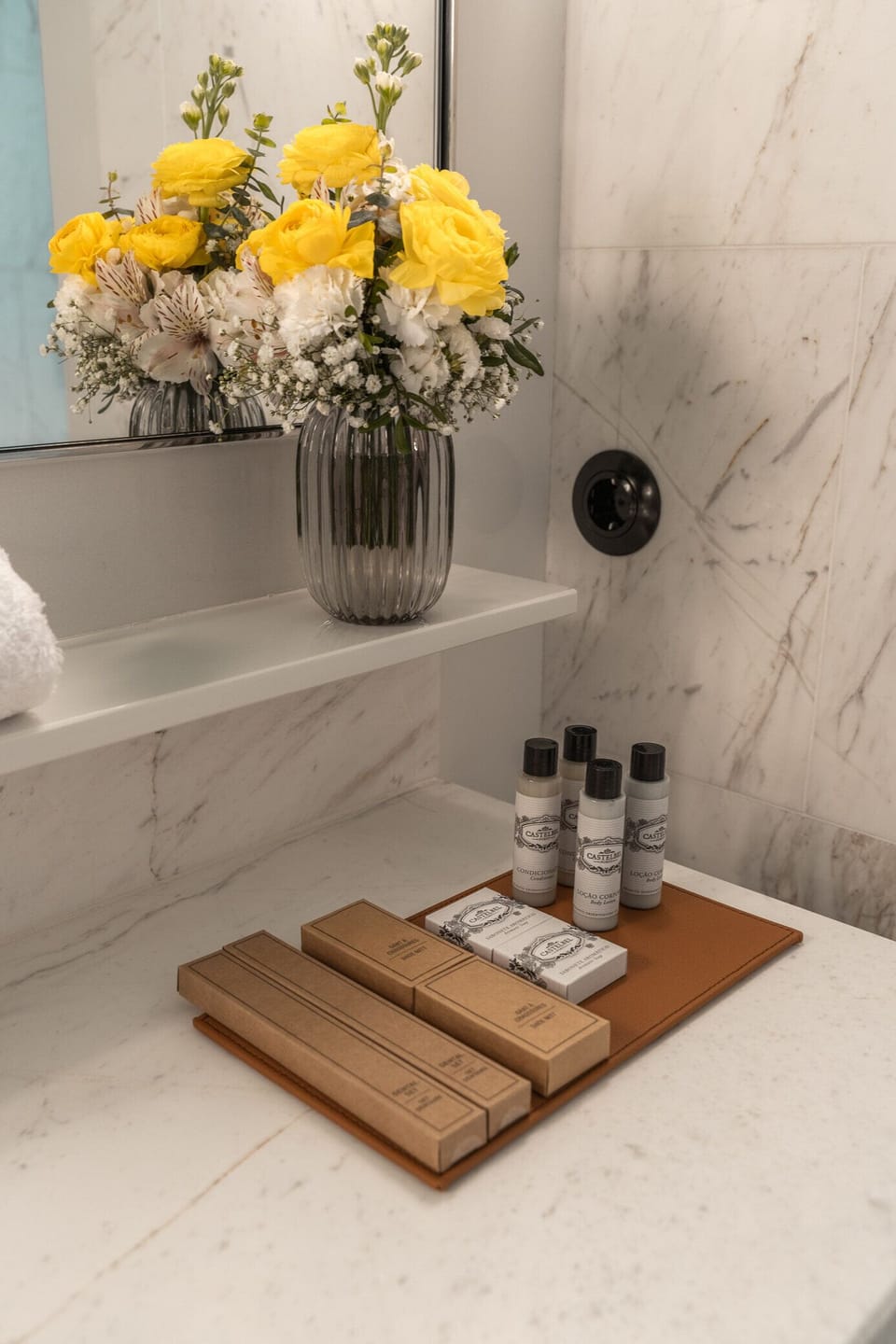 Indulge in thoughtful toiletries and fresh blooms by the sink.