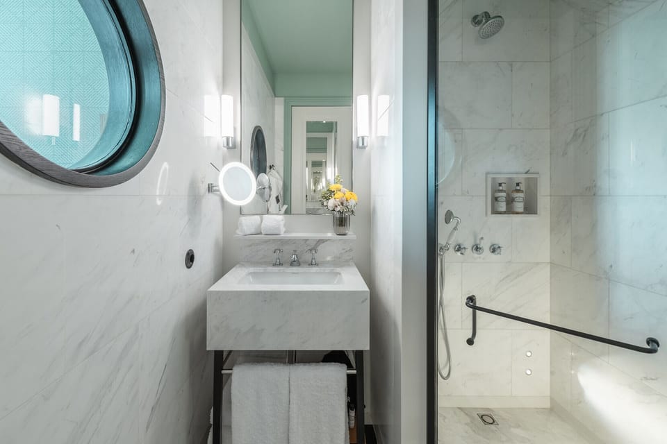 Refresh in a sleek marble bathroom with a walk-in shower.