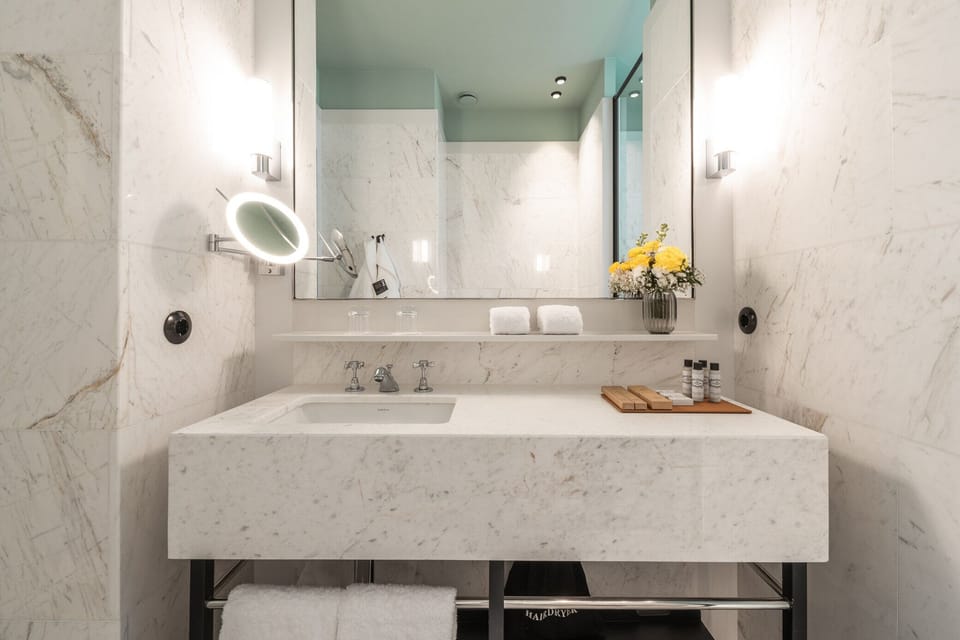 Refresh at the sleek marble vanity with spa-like lighting.
