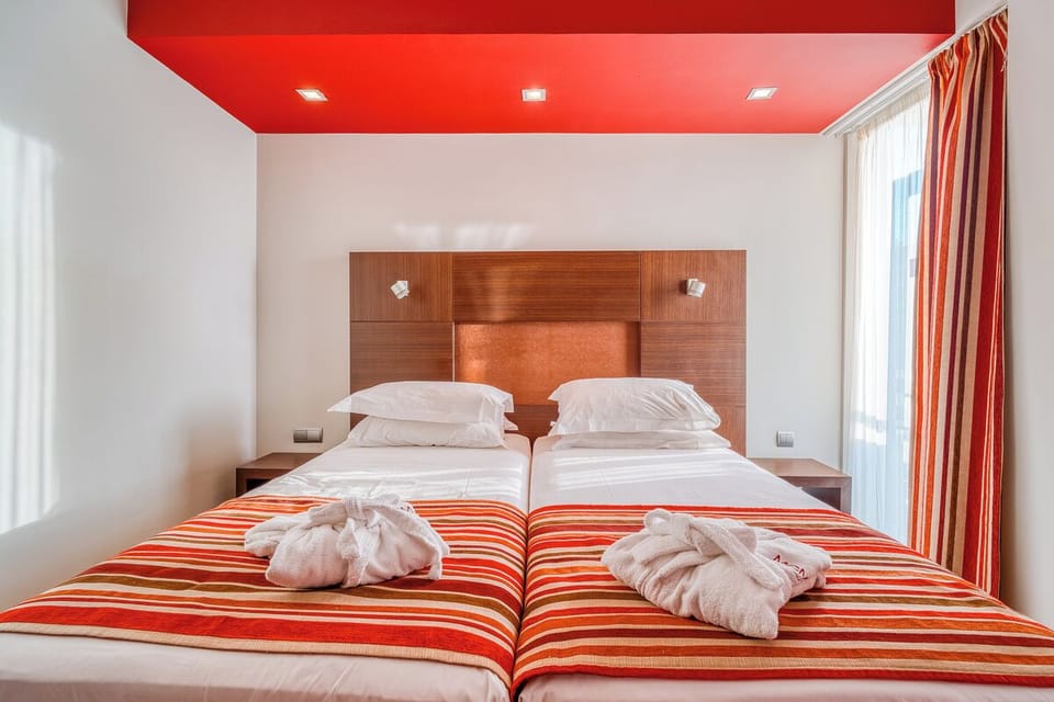 Sink into crisp twin beds under warm, modern lighting.