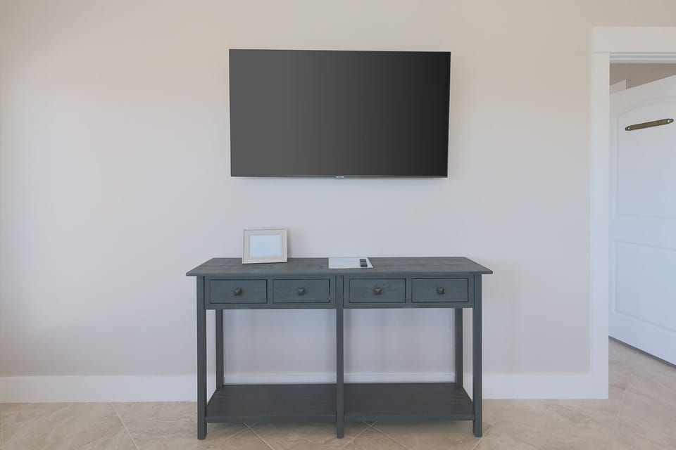 A stylish console table with drawers complements the mounted TV, creating a cozy and inviting living space