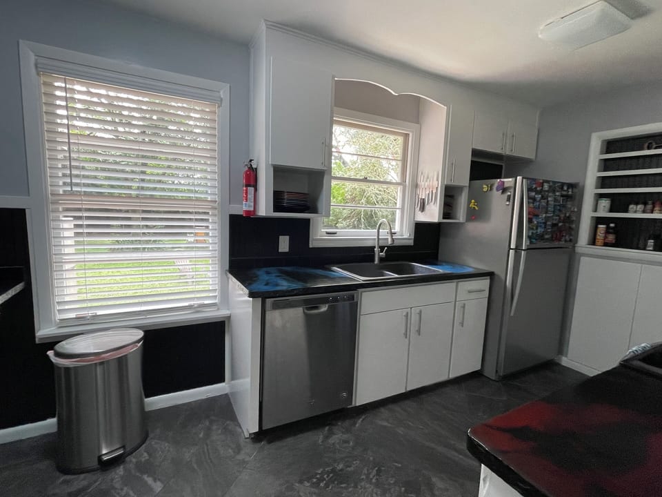 kitchen with stainless appliances, view into backyard, pots, pans, & essentials