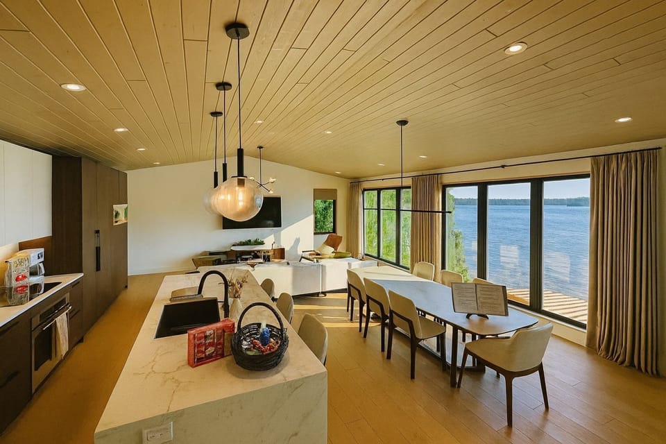 Spacious dining area beside the chef’s kitchen, offering sweeping lake views through sliding glass doors.