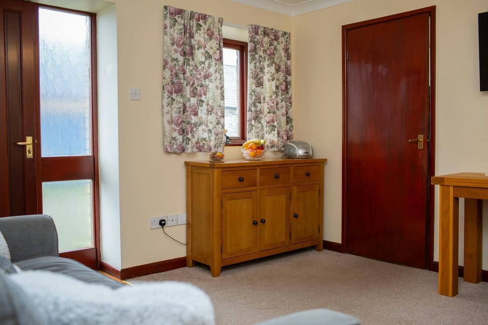 Sitting room with sofa and door leading to the front seating area of the cottage