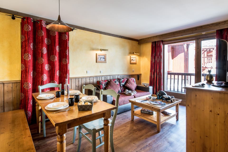 Comfortable living room with balcony access and plenty of natural light for relaxed alpine stays.