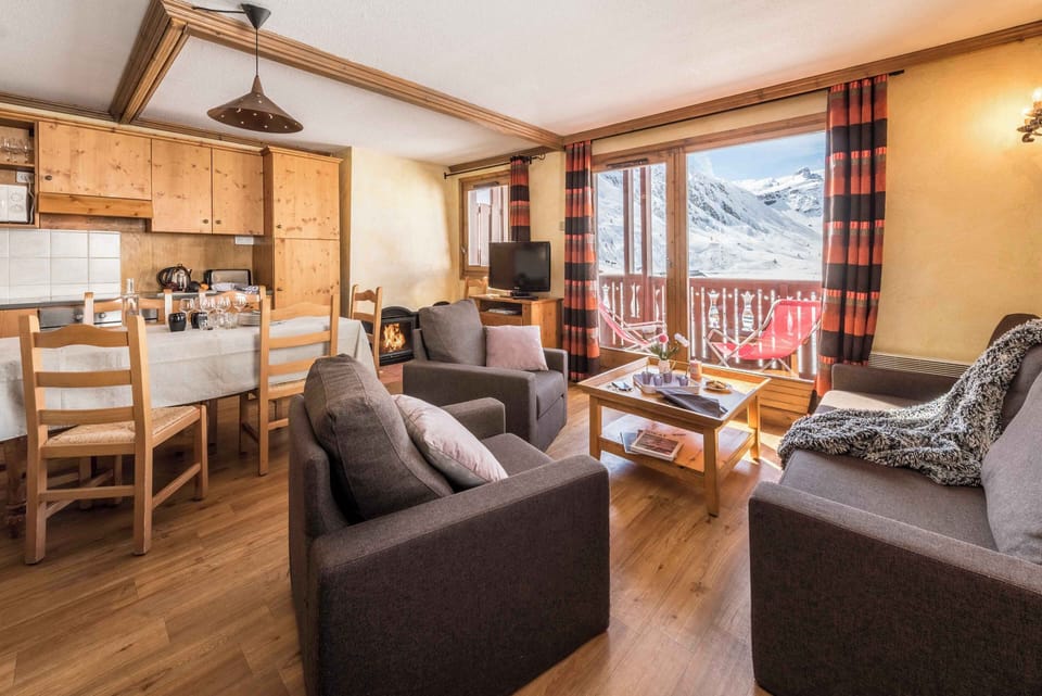 Bright open-plan living and dining area with mountain views and balcony access.
