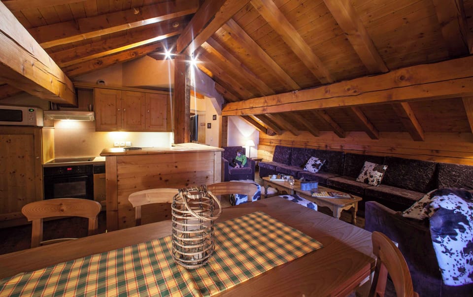 Large open-plan lounge and dining area beneath exposed beams, ideal for group meals and downtime.