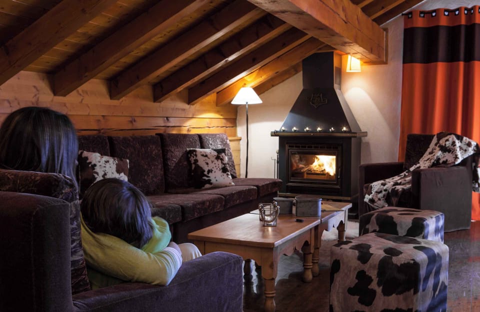 Spacious living room with fireplace and alpine charm, perfect for gathering after a day on the pistes.