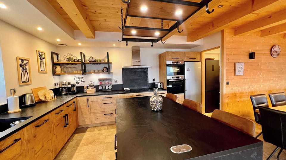 Grande cuisine entièrement équipée avec deux réfrigérateurs, deux fours et tout le nécessaire pour cuisiner comme à la maison. Fonctionnelle et spacieuse, elle permet de préparer facilement de bons repas pour toute la famille.
