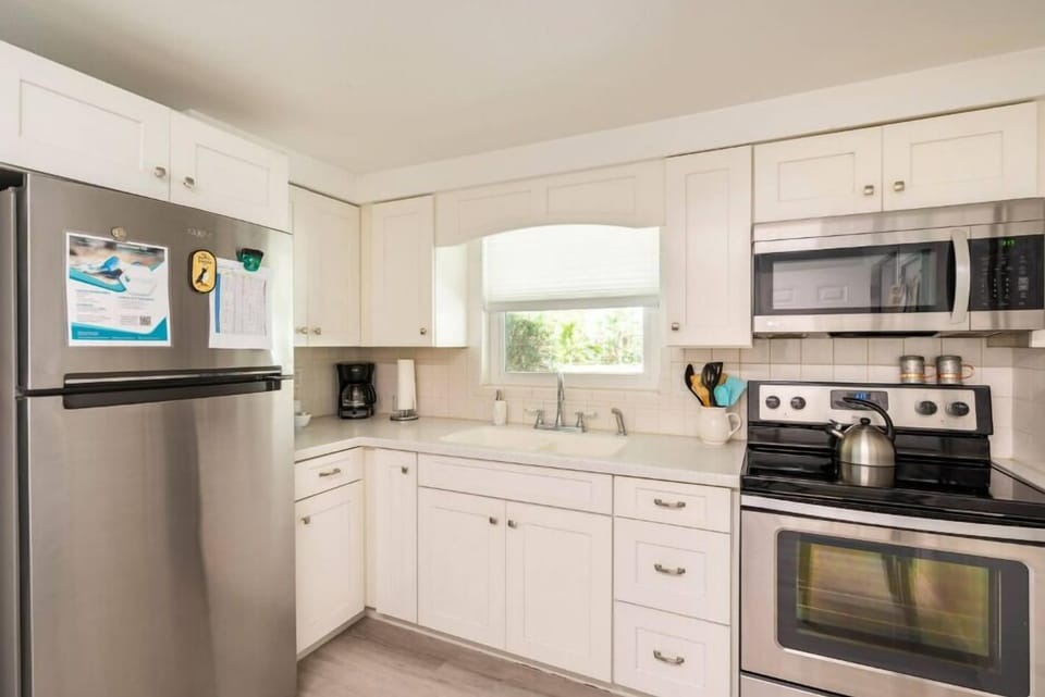 Fully furnished kitchen with amenities like a refrigerator, stove, oven, water kettle, and coffee maker.