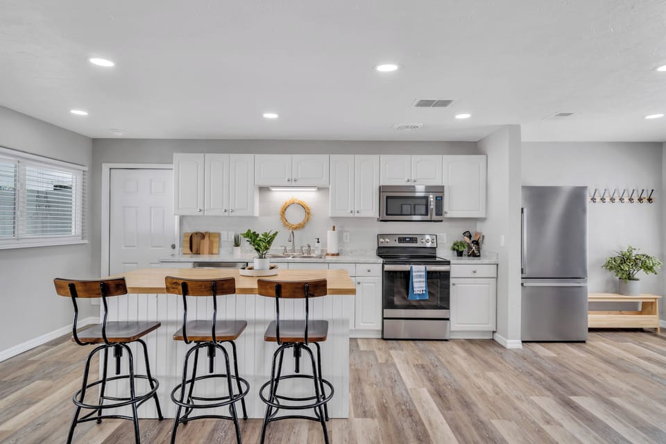 Expansive and bright, this kitchen has abundant cabinet space, ensuring seamless organization. The entire space is filled with generous lighting, its open design offers a spacious, inviting culinary haven.