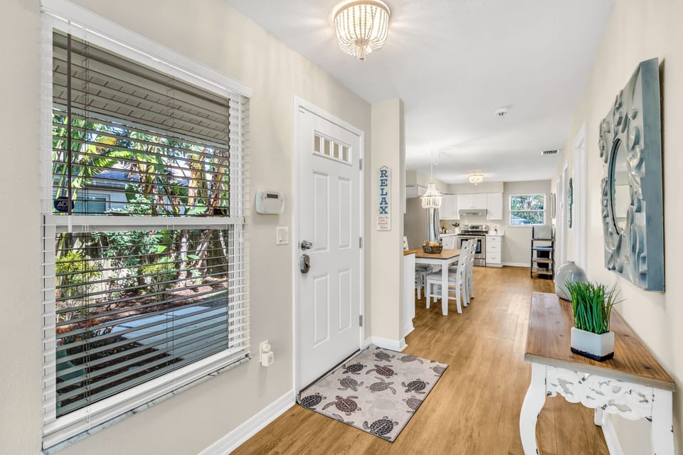 You'll first enter into the quaint foyer where a convenient table is placed for you to set your handbags and other items down. The dining room and kitchen then follows.