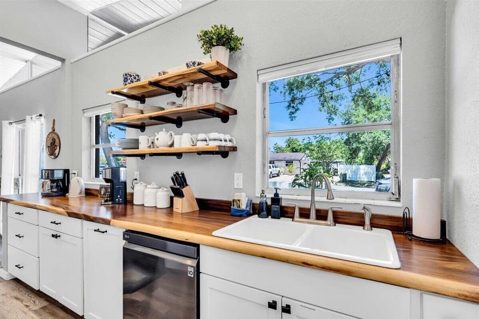 Kitchen equipped with sink with a window to let in plenty of natural sunlight.