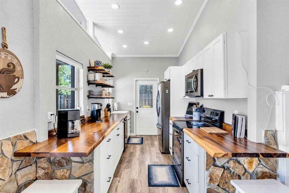 A sleek, contemporary kitchen designed for efficiency and style. Modern appliances streamline meal prep, while a convenient coffee corner boasts a traditional coffee maker and Keurig for versatile brewing. The dishwasher ensures an easy cleanup.