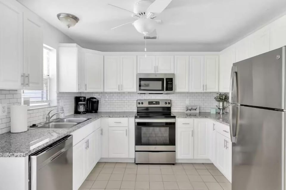 Fully stocked kitchen with plates, cups, and utensils.