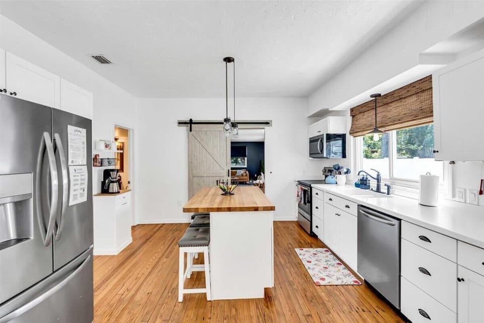 The full-size kitchen is complete with modern appliances including a fridge, dishwasher, stove, and microwave.