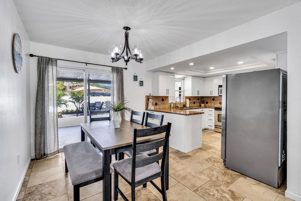 A charming dining room seamlessly connected to the kitchen, showcasing a welcoming space with 4 chairs and a bench on the opposite side. The warm ambiance invites shared meals, while the proximity to the kitchen ensures convenience.