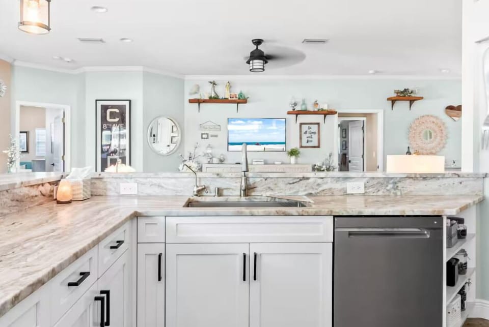 Kitchen equipped with a spacious countertop, sink, & dishwasher.