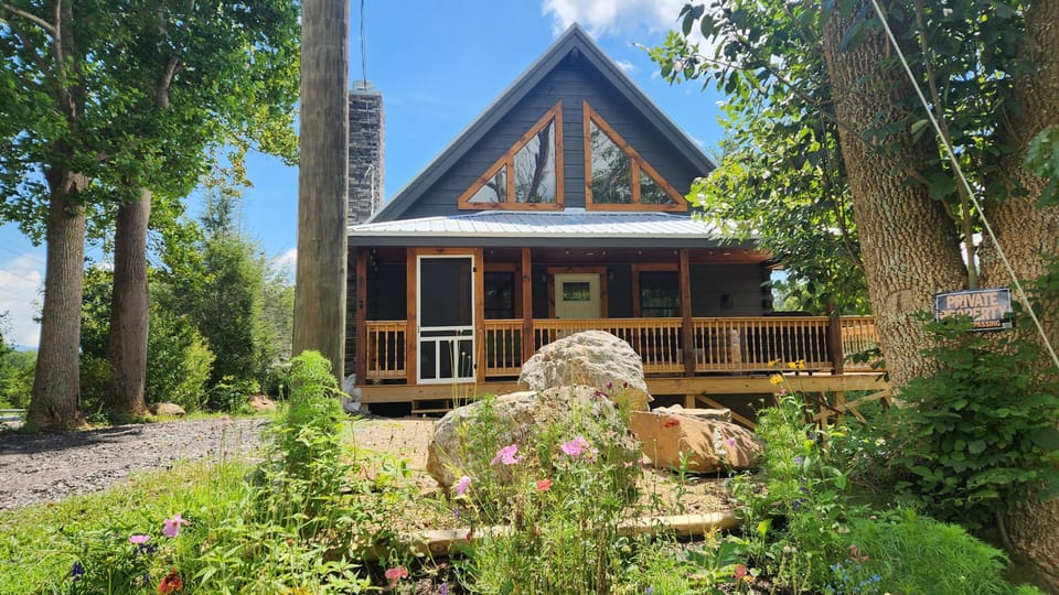 Brand new log cabin August 2025 with wildflowers in landscaping