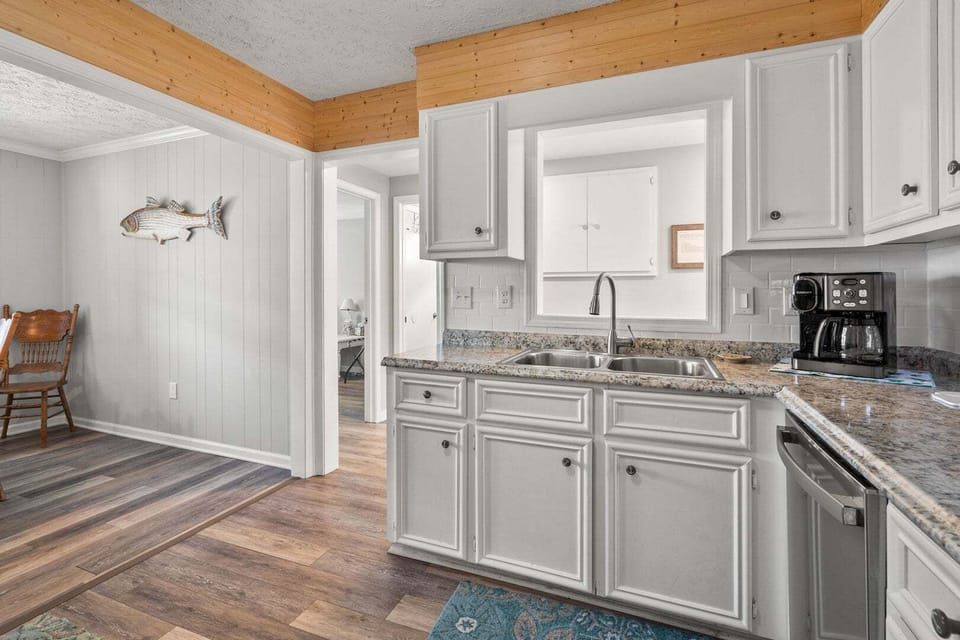 White cabinetry, wooden ceiling beams and a coffee maker in the kitchen at Wells Tales in North Myrtle Beach