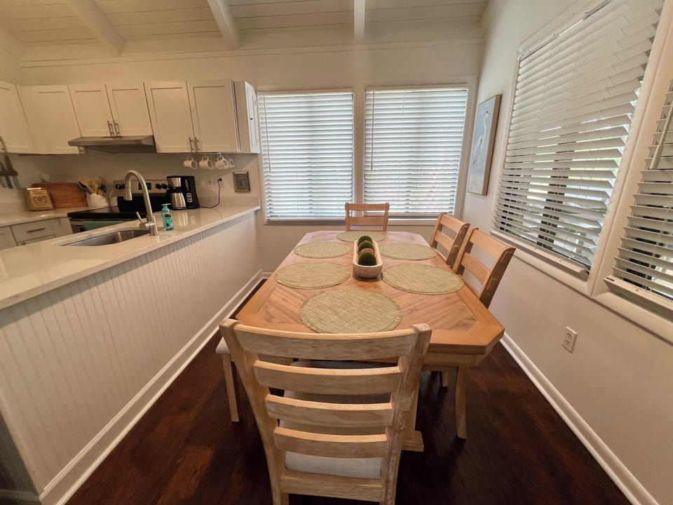 The dining area overlooks the bright kitchen, which is fully equipped for preparing family meals.